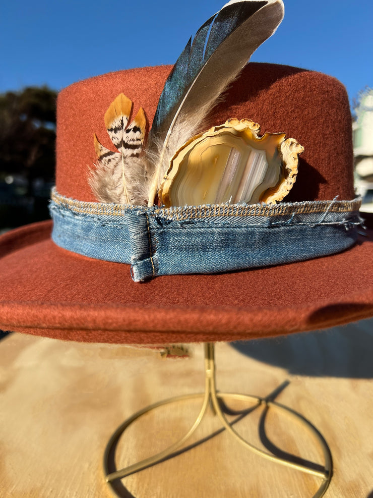 Billy Jean. Orange wool fedora hat with white/brown Agate slice and feathers in brown, orange, white and blue. Vintage blue denim band and gold Elemant stitched on gold emblem.