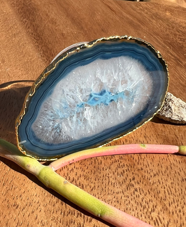 Blue Agate pop socket (popsocket) for use with iphone, androids, ipads, smartphones, and other small tecnical devices. Used for easy grip of electronics as well as a beautiful phone accessory. It is an attachment that easily tapes onto the back of the device and pops in and out as needed for use. These agate slices are natural and pure agate stones imported from Brazil of the highest quality and beautifylly gold dipped on the rim.
