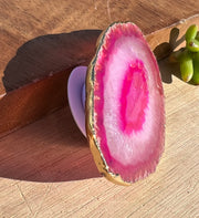 Pink Agate pop socket (popsocket) for use with iphone, androids, ipads, smartphones and other small tecnical devices. Used for easy grip of electronics as well as a beautiful phone accessory. It is an attachment that easily tapes onto the back of the device and pops in and out as needed for use. These agate slices are natural and pure agate stones imported from Brazil of the highest quality and beautifylly gold dipped on the rim.