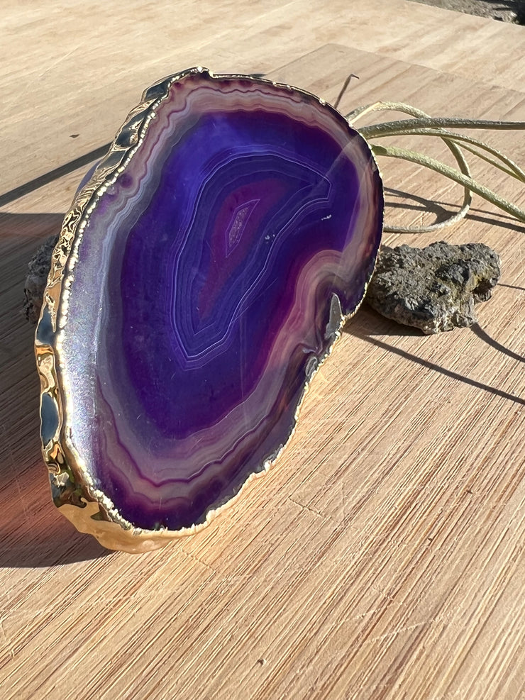 Purple Agate pop socket (popsocket) for use with iphone, androids, ipads, smartphones and other small tecnical devices. Used for easy grip of electronics as well as a beautiful phone accessory. It is an attachment that easily tapes onto the back of the device and pops in and out as needed for use. These agate slices are natural and pure agate stones imported from Brazil of the highest quality and beautifylly gold dipped on the rim.