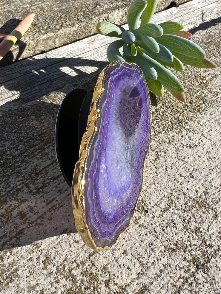 Purple Agate pop socket (popsocket) for use with iphone, androids, ipads, smartphones and other small tecnical devices. Used for easy grip of electronics as well as a beautiful phone accessory. It is an attachment that easily tapes onto the back of the device and pops in and out as needed for use. These agate slices are natural and pure agate stones imported from Brazil of the highest quality and beautifylly gold dipped on the rim.