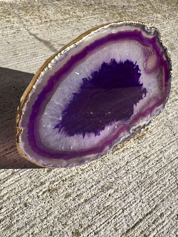 Purple Agate pop socket (popsocket) for use with iphone, androids, ipads, smartphones and other small tecnical devices. Used for easy grip of electronics as well as a beautiful phone accessory. It is an attachment that easily tapes onto the back of the device and pops in and out as needed for use. These agate slices are natural and pure agate stones imported from Brazil of the highest quality and beautifylly gold dipped on the rim.
