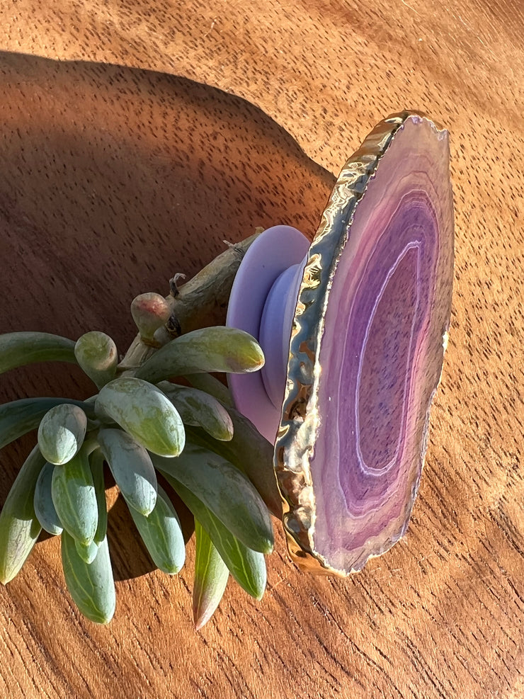 Purple Agate pop socket (popsocket) for use with iphone, androids, ipads, smartphones and other small tecnical devices. Used for easy grip of electronics as well as a beautiful phone accessory. It is an attachment that easily tapes onto the back of the device and pops in and out as needed for use. These agate slices are natural and pure agate stones imported from Brazil of the highest quality and beautifylly gold dipped on the rim.