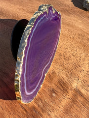 Purple Agate pop socket (popsocket) for use with iphone, androids, ipads, smartphones and other small tecnical devices. Used for easy grip of electronics as well as a beautiful phone accessory. It is an attachment that easily tapes onto the back of the device and pops in and out as needed for use. These agate slices are natural and pure agate stones imported from Brazil of the highest quality and beautifylly gold dipped on the rim.