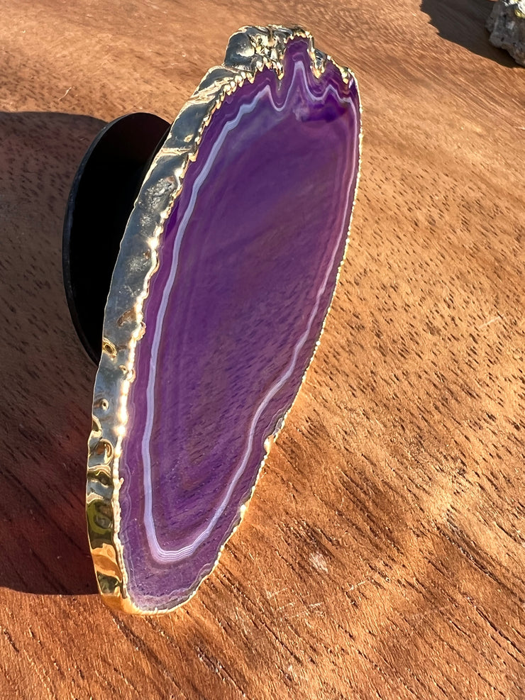 Purple Agate pop socket (popsocket) for use with iphone, androids, ipads, smartphones and other small tecnical devices. Used for easy grip of electronics as well as a beautiful phone accessory. It is an attachment that easily tapes onto the back of the device and pops in and out as needed for use. These agate slices are natural and pure agate stones imported from Brazil of the highest quality and beautifylly gold dipped on the rim.