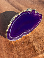 Purple Agate pop socket (popsocket) for use with iphone, androids, ipads, smartphones and other small tecnical devices. Used for easy grip of electronics as well as a beautiful phone accessory. It is an attachment that easily tapes onto the back of the device and pops in and out as needed for use. These agate slices are natural and pure agate stones imported from Brazil of the highest quality and beautifylly gold dipped on the rim.