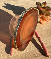 Red Agate pop socket (popsocket) for use with iphone, androids, ipads, smartphones and other small tecnical devices. Used for easy grip of electronics as well as a beautiful phone accessory. It is an attachment that easily tapes onto the back of the device and pops in and out as needed for use. These agate slices are natural and pure agate stones imported from Brazil of the highest quality and beautifylly gold dipped on the rim.