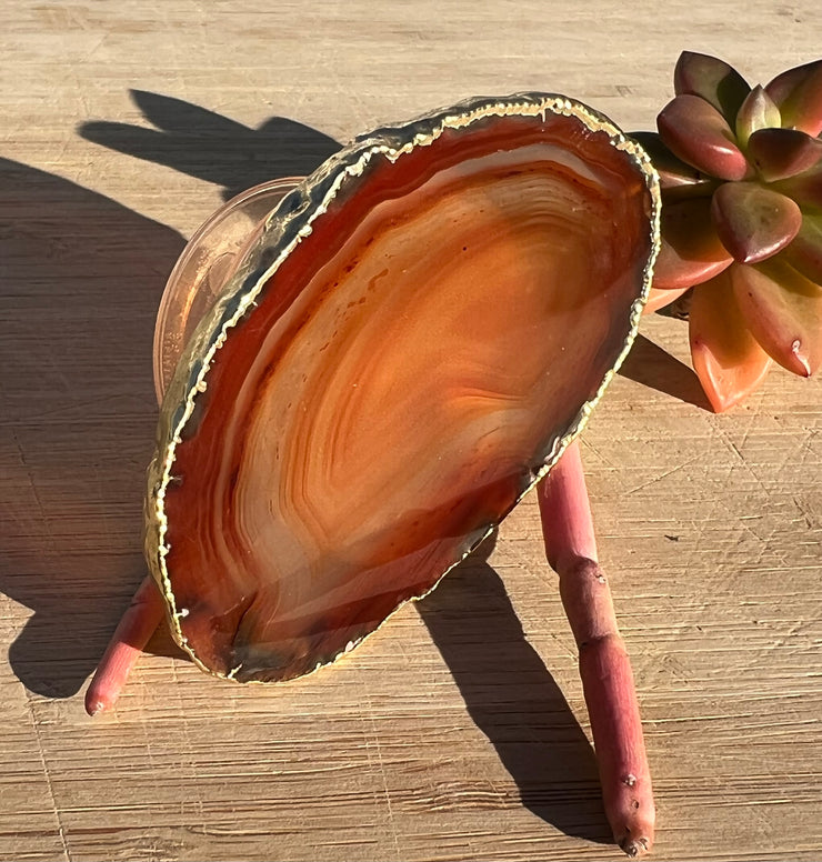 Red Agate pop socket (popsocket) for use with iphone, androids, ipads, smartphones and other small tecnical devices. Used for easy grip of electronics as well as a beautiful phone accessory. It is an attachment that easily tapes onto the back of the device and pops in and out as needed for use. These agate slices are natural and pure agate stones imported from Brazil of the highest quality and beautifylly gold dipped on the rim.