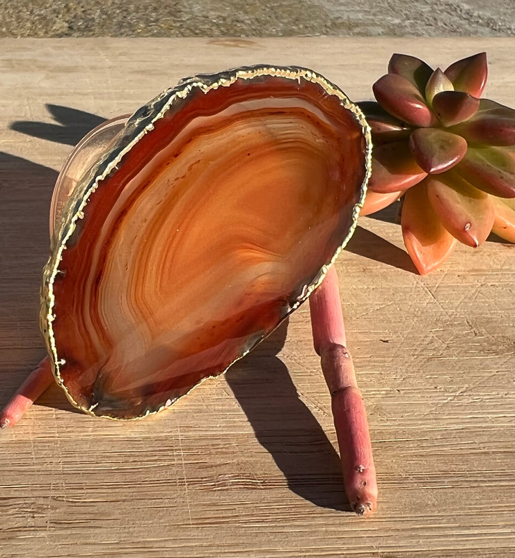 Red Agate pop socket (popsocket) for use with iphone, androids, ipads, smartphones and other small tecnical devices. Used for easy grip of electronics as well as a beautiful phone accessory. It is an attachment that easily tapes onto the back of the device and pops in and out as needed for use. These agate slices are natural and pure agate stones imported from Brazil of the highest quality and beautifylly gold dipped on the rim.