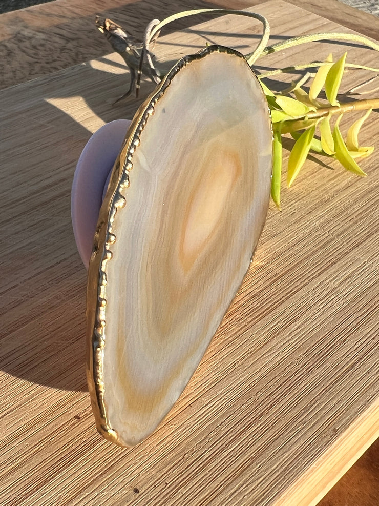 White Agate pop socket (popsocket) for use with iphone, androids, ipads, smartphones and other small tecnical devices. Used for easy grip of electronics as well as a beautiful phone accessory. It is an attachment that easily tapes onto the back of the device and pops in and out as needed for use. These agate slices are natural and pure agate stones imported from Brazil of the highest quality and beautifylly gold dipped on the rim.