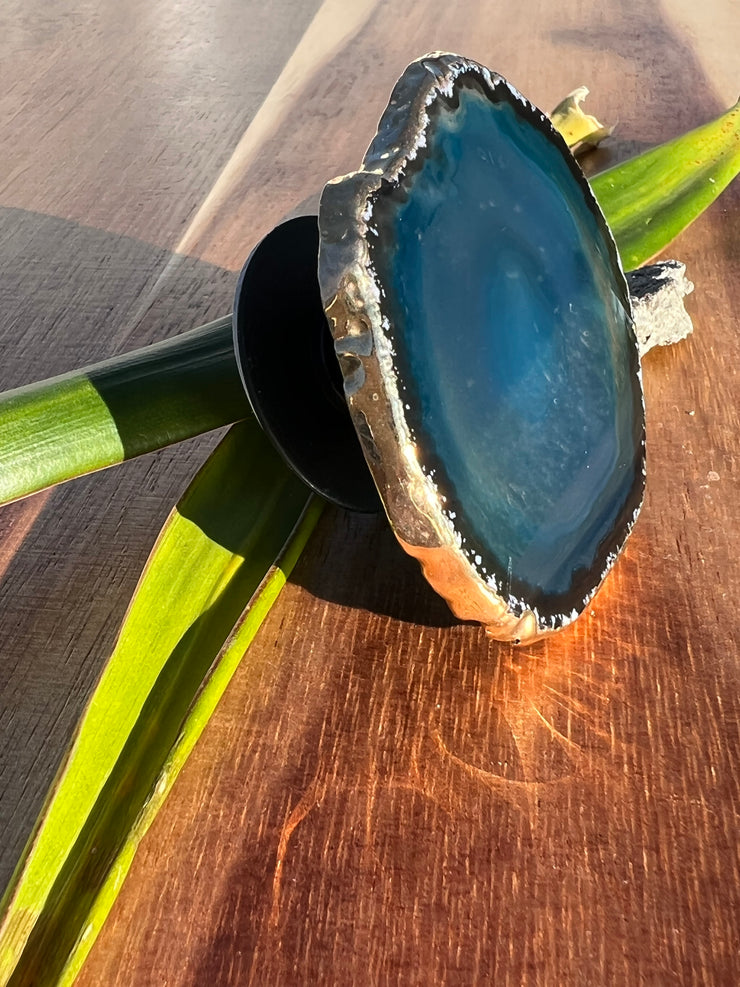 Blue Agate pop socket (popsocket) for use with iphone, androids, ipads, smartphones, and other small tecnical devices. Used for easy grip of electronics as well as a beautiful phone accessory. It is an attachment that easily tapes onto the back of the device and pops in and out as needed for use. These agate slices are natural and pure agate stones imported from Brazil of the highest quality and beautifylly gold dipped on the rim.