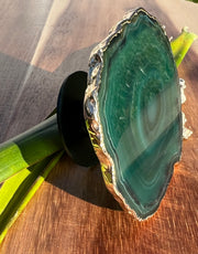 Green Agate pop socket (popsocket) for use with iphone, androids, ipads, smartphones and other small tecnical devices. Used for easy grip of electronics as well as a beautiful phone accessory. It is an attachment that easily tapes onto the back of the device and pops in and out as needed for use. These agate slices are natural and pure agate stones imported from Brazil of the highest quality and beautifylly gold dipped on the rim.