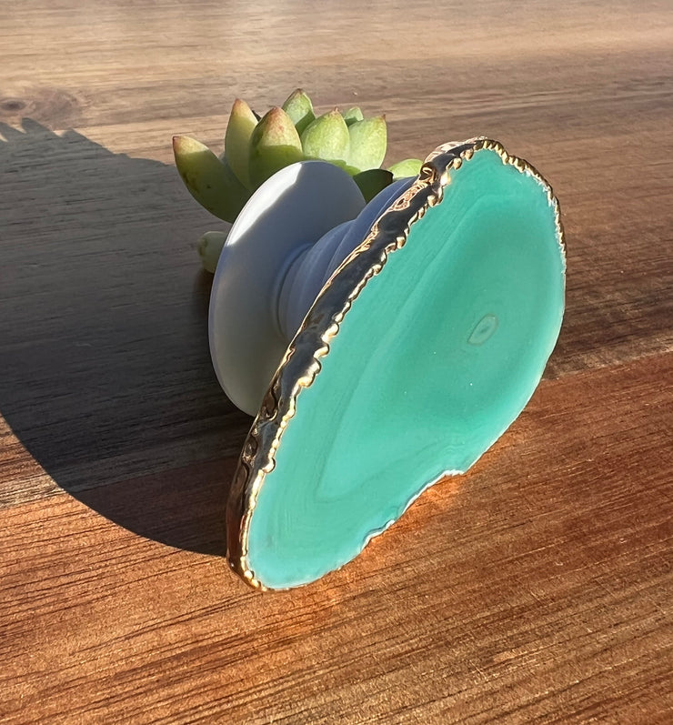 Green Agate pop socket (popsocket) for use with iphone, androids, ipads, smartphones and other small tecnical devices. Used for easy grip of electronics as well as a beautiful phone accessory. It is an attachment that easily tapes onto the back of the device and pops in and out as needed for use. These agate slices are natural and pure agate stones imported from Brazil of the highest quality and beautifylly gold dipped on the rim.