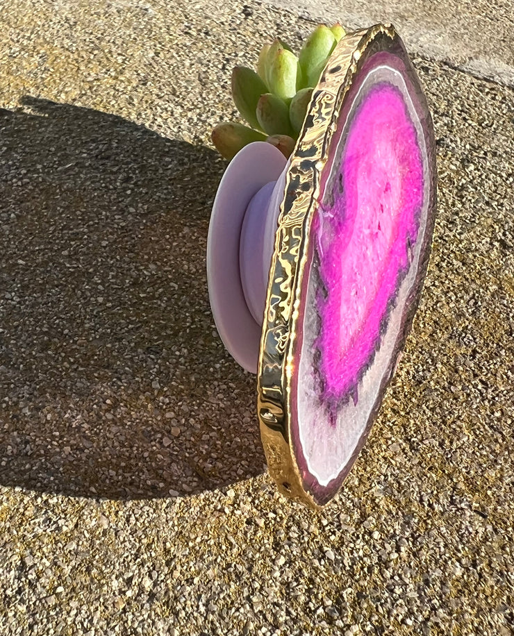Pink Agate pop socket (popsocket) for use with iphone, androids, ipads, smartphones and other small tecnical devices. Used for easy grip of electronics as well as a beautiful phone accessory. It is an attachment that easily tapes onto the back of the device and pops in and out as needed for use. These agate slices are natural and pure agate stones imported from Brazil of the highest quality and beautifylly gold dipped on the rim.