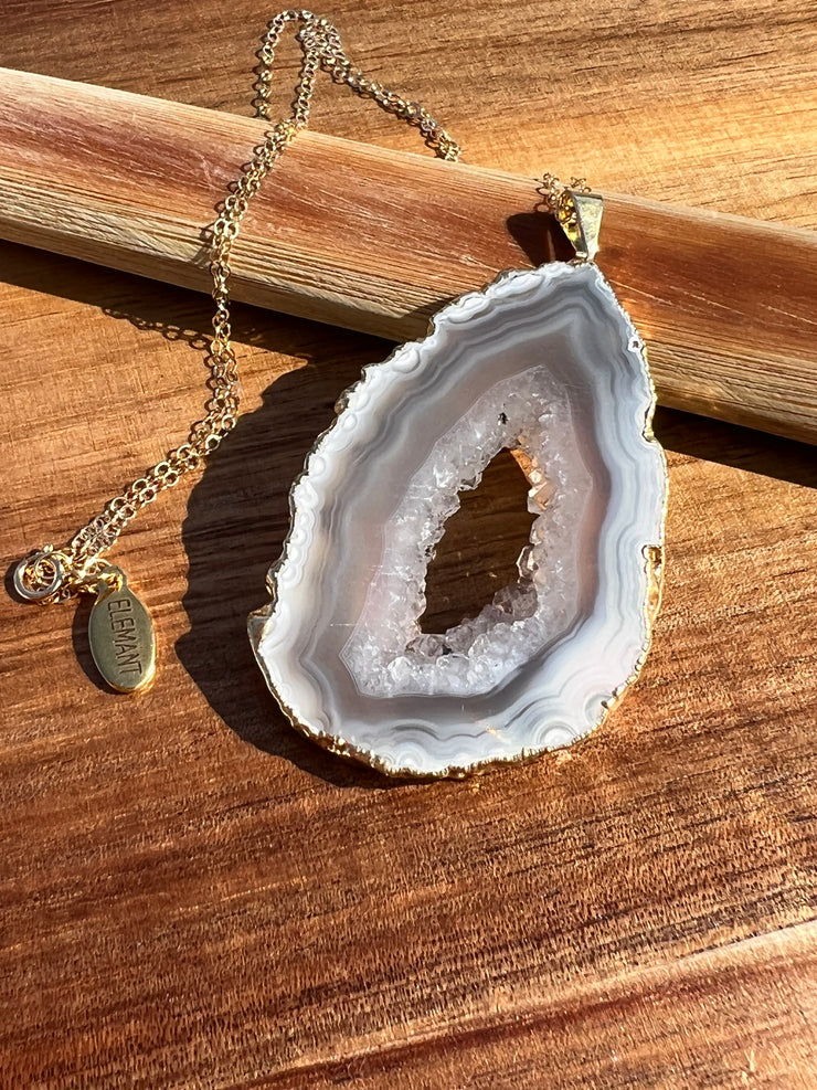Natural Agate slice druzy necklace pendant, gold rimmed. Varies in hues, size, shape and tones. Comes with durable 14k gold filled chain length 16inches (41cm) and Elemant logo tag in gold attached by the clasp. Beautifully crafted natural agate stones in highest quality imported from Brazil.