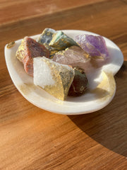 Onyx bowl with 7 different meditation stones inside. White Quartz, Rose Quartz, Green Quartz, Blue Quartz, Red Jasper, Amethyst and Orange Calcite. A gold Elemant logo emblem is attached to the bowl and both the bowl and stones are artfully gold dusted. Includes a note describing each of the meditation stones meaning and benefits.