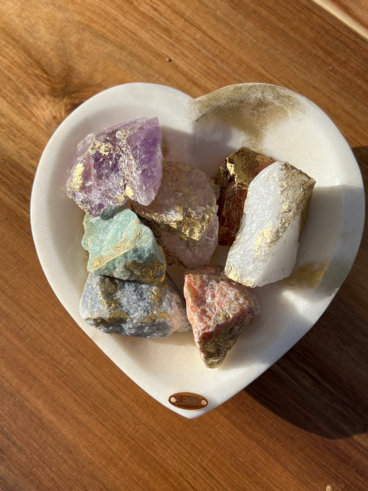 Onyx bowl with 7 different meditation stones inside.  White Quartz, Rose Quartz, Green Quartz, Blue Quartz, Red Jasper, Amethyst and Orange Calcite.  A gold Elemant logo emblem is attached to the bowl and both the bowl and stones are artfully gold dusted.  Includes a note describing each of the meditation stones meaning and benefits.