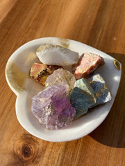 Onyx bowl with 7 different meditation stones inside. White Quartz, Rose Quartz, Green Quartz, Blue Quartz, Red Jasper, Amethyst and Orange Calcite. A gold Elemant logo emblem is attached to the bowl and both the bowl and stones are artfully gold dusted. Includes a note describing each of the meditation stones meaning and benefits.