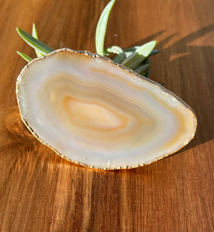 White Agate pop socket (popsocket) for use with iphone, androids, ipads, smartphones and other small tecnical devices. Used for easy grip of electronics as well as a beautiful phone accessory. It is an attachment that easily tapes onto the back of the device and pops in and out as needed for use. These agate slices are natural and pure agate stones imported from Brazil of the highest quality and beautifylly gold dipped on the rim.