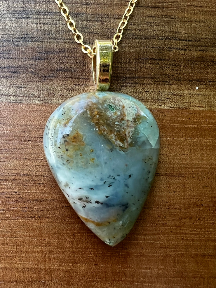 Opal pendant with layered 14k gold filled chains.  An oval long chained link and a thinner longer gold chain that the Opal hangs from.  A gold Elemant logo emblem is attached at the clasp. Opal is the stone of abundance, fortune, luck, health and wealth.