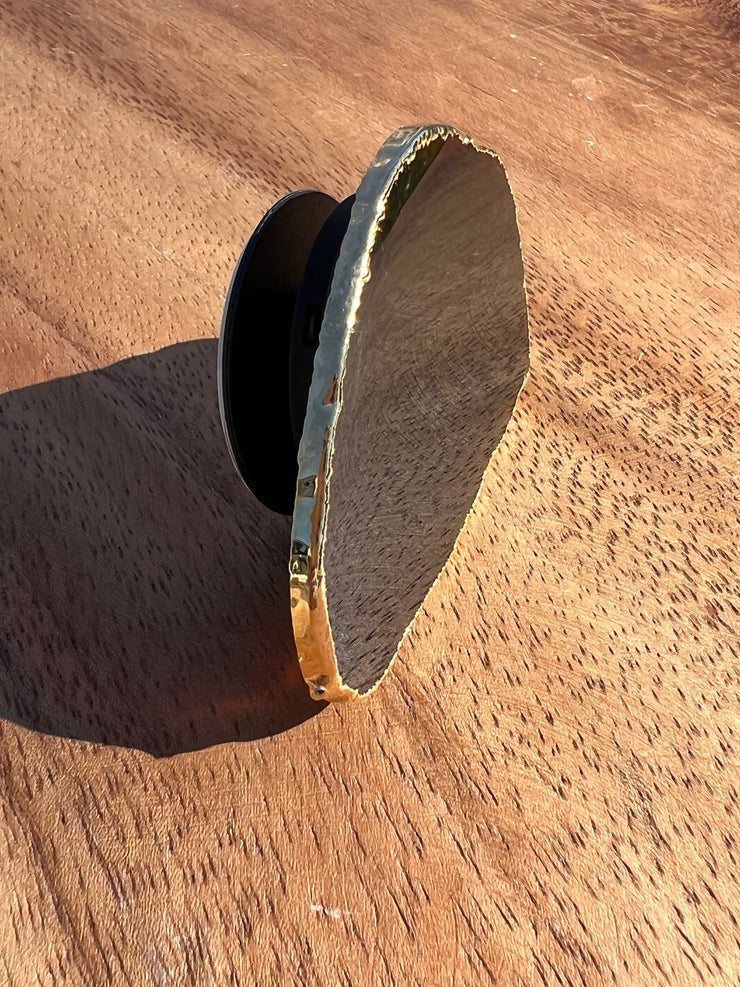 Black Agate pop socket (popsocket) for use with iphone, androids, ipads, smartphones, and other small tecnical devices. Used for easy grip of electronics as well as a beautiful phone accessory. It is an attachment that easily tapes onto the back of the device and pops in and out as needed for use. These agate slices are natural and pure agate stones imported from Brazil of the highest quality and beautifylly gold dipped on the rim.