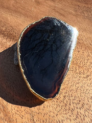 Black Agate pop socket (popsocket) for use with iphone, androids, ipads, and other small tecnical devices. Used for easy grip of electronics as well as a beautiful phone accessory. It is an attachment that easily tapes onto the back of the device and pops in and out as needed for use. These agate slices are natural and pure agate stones imported from Brazil of the highest quality and beautifylly gold dipped on the rim.