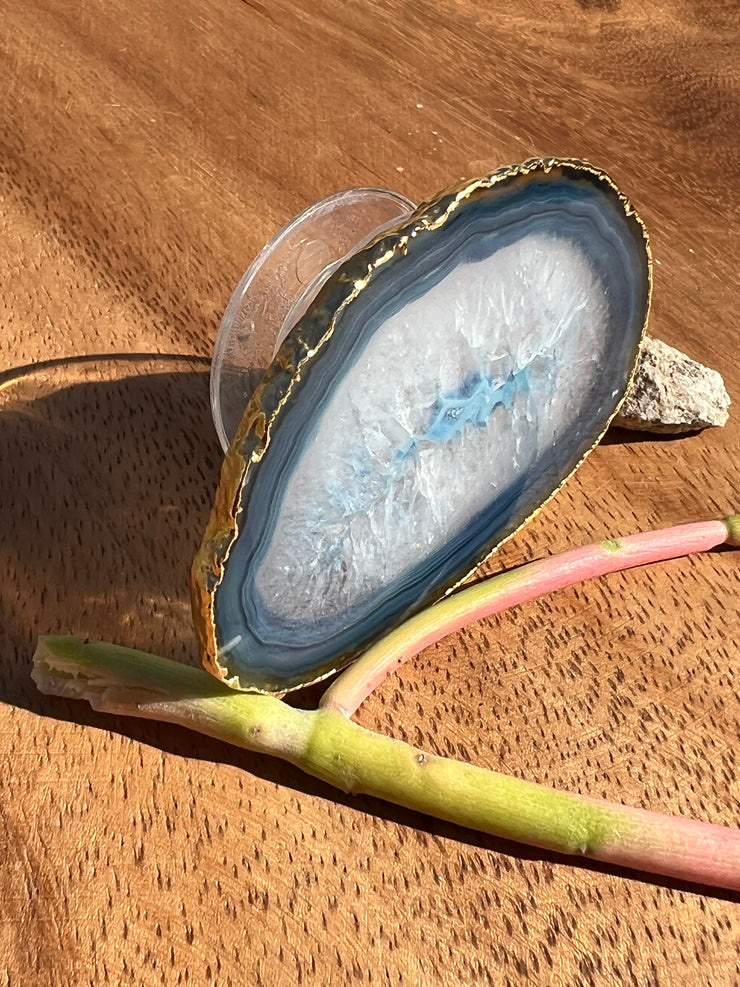 Blue Agate pop socket (popsocket) for use with iphone, androids, ipads, smartphones, and other small tecnical devices. Used for easy grip of electronics as well as a beautiful phone accessory. It is an attachment that easily tapes onto the back of the device and pops in and out as needed for use. These agate slices are natural and pure agate stones imported from Brazil of the highest quality and beautifylly gold dipped on the rim.